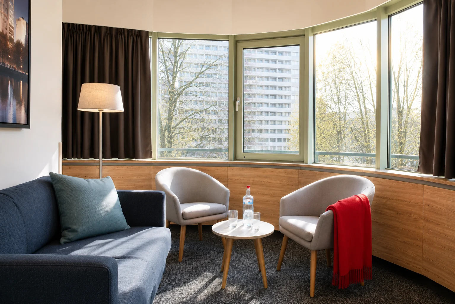 Panoramaværelsets sofahjørne med to lænestole, sofabord og bay-window-udsigt